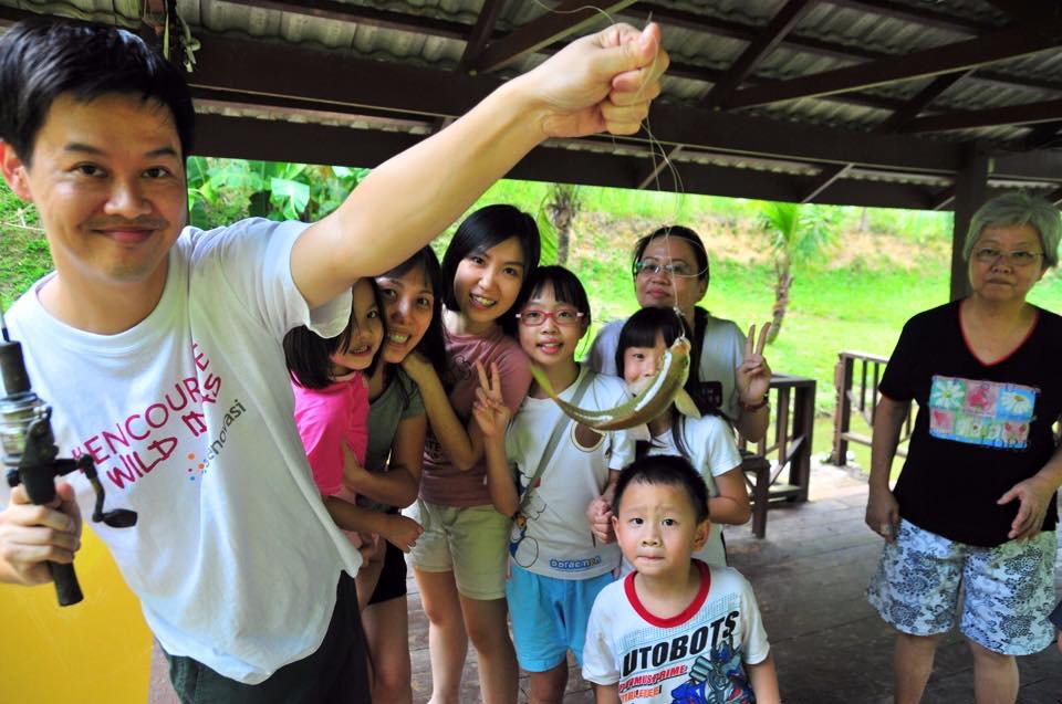 A family holding up their catch from the pond